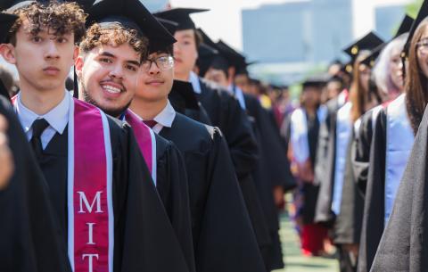 Image of an undergraduate student in the academic procession smiling