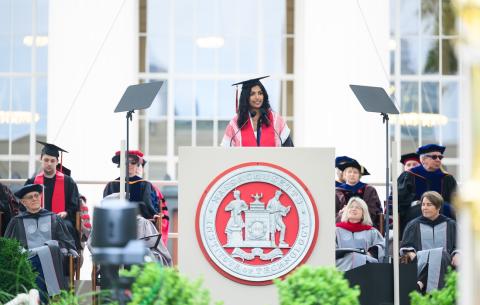Image of Megha Vemuri speaking at the podium during the OneMIT Commencement Ceremony
