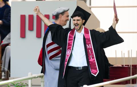 Image of the graduate walking with his diploma at the Undergraduate Ceremony