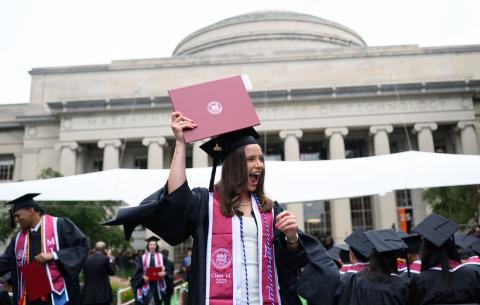 Image of a graduate walking with her diploma at the Undergraduate Ceremony